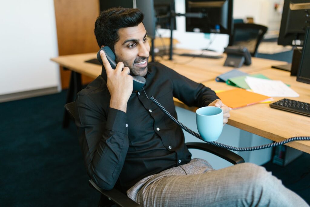Medewerker belt vanaf zijn bureau op kantoor